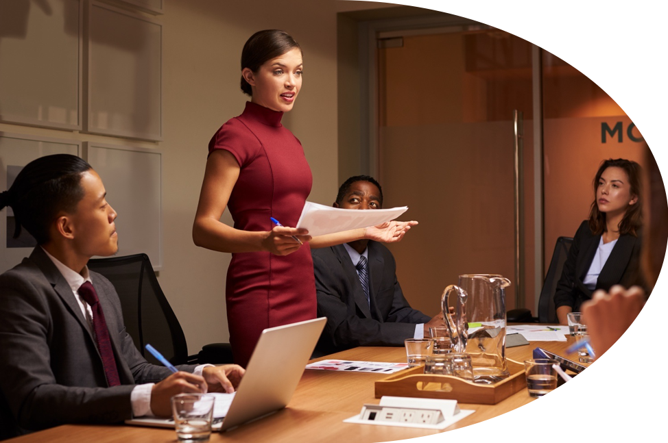 Helping leaders to command more effective leadership: a woman in red dress presenting in a formal meeting. 